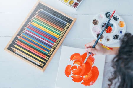 Essential painting supplies. Flat lay of colored pencils set, palette on white wooden floor. Artist creating abstract floral artwork.の写真素材
