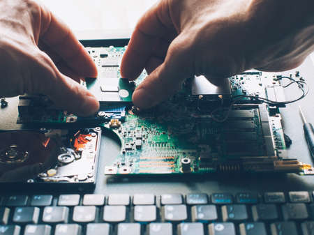 Computer upgrade. Processor installation. Technician plugging CPU microprocessor into motherboard socket.の写真素材