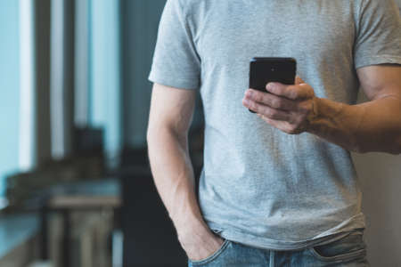 Modern business communication. Cropped shot of man holding smartphone, texting message. Copy space.の写真素材