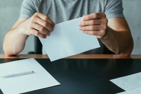 Written communication. Cropped shot of man folding blank mockup letter to send. Copy space.の写真素材