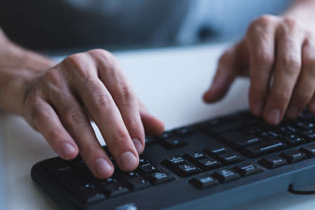 Software developer at work. Closeup of male programmer hands using keyboard to write code.の写真素材