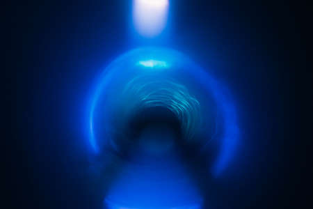 Blur neon blue arc glow. Colored lens flare. Dark abstract background. Tunnel effect.