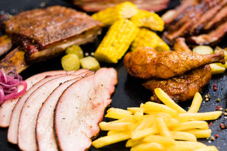 Grill restaurant menu. Roasted meat, poultry assortment, French fries, baked Bonduelle corn.の写真素材