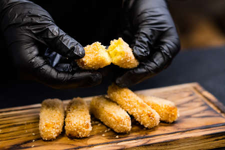 Culinary master class. Chef showing how polenta fries in panko breadcrumbs look inside.の写真素材