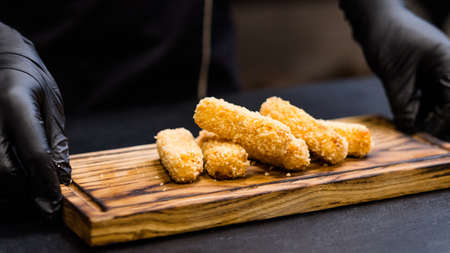 Italian food recipe. Chef serving polenta fries in panko breadcrumbs on wooden board.の写真素材