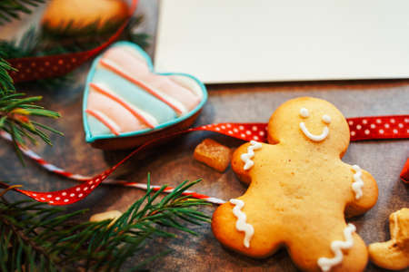 Christmas food gift. Closeup of homemade gingerbread man and heart cookies over blur blank white...