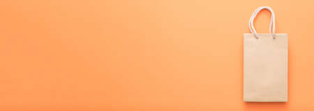 Shopping hobby. Purchase consumerism discount. Paper bag brand mockup. Orange background.