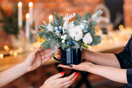 New year party gift. Closeup of fir tree arrangement with white fake snow, deer and cotton plant in mug.の写真素材