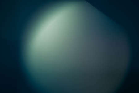 Defocused light spot. Teal blue abstract art background. Colored lens flare. Blur round flash glow.