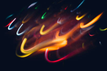 Blur party lights. Neon multicolor glowing curvy lines. Dark abstract background.の写真素材