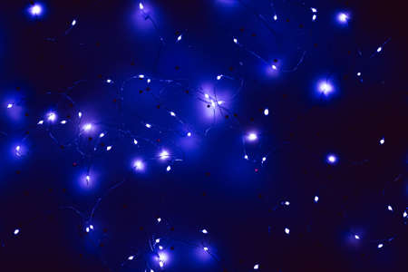 Cold white LED string lights on star pattern navy blue background. Modern festive interior decor.の写真素材