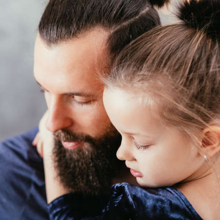 Happy father and daughter relationship. Closeup portrait of cute little girl hugging her loving daddy.の写真素材