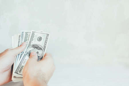 Currency exchange. Hundred dollar bills. Man hands with cash money. White background.の写真素材