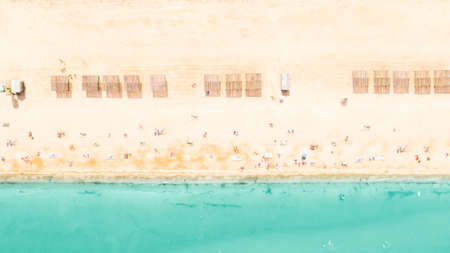 Seashore landscape from above. Summer resort. Tourists sunbathing on sandy beach at turquoise water.の写真素材