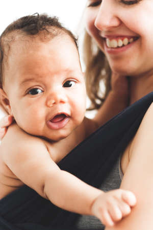 New life. Motherhood parenting care. Happy mom holding newborn African baby.の写真素材