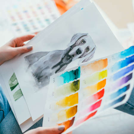 Painting hobby. Inspiration art skills. Woman holding artwork of dog color swatch.の写真素材