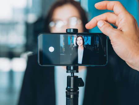 Business coaching. Professional video blog. Male assistant recording successful woman interview.の写真素材