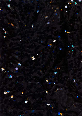 Textile abstract background. Draped fabric. Black material with shiny iridescent sequin decor.の写真素材