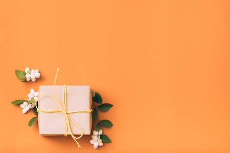 Birthday present. Greeting. Gift box. Mistletoe decor Orange background