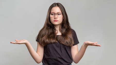 Confident woman portrait. Female power. Strong smart lady in eyeglasses isolated on gray background....