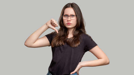 Confident woman portrait. Female power. Strong smart lady in eyeglasses isolated on gray background....