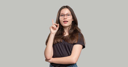 Confident woman portrait. Female power. Strong smart lady in eyeglasses isolated on gray background. Feminism protest. Skeptic activist. Gender equality.の写真素材