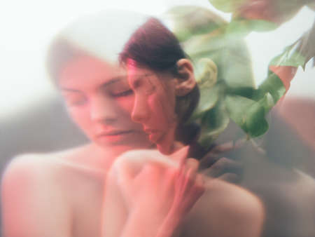 Feminine portrait. Harmony balance. Sensual woman blur silhouette in neon red light with floral...