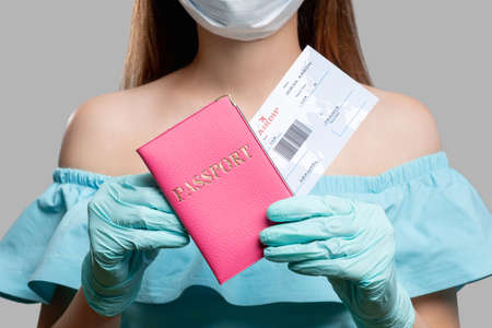 Passport control. Pandemic prevention. Woman with id and boarding pass. COVID-19 protection. Traveling after quarantineの写真素材
