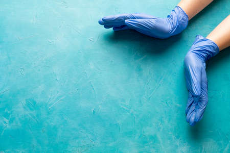 Pandemic prevention. Disease hygiene. Doctor opened hands in protective gloves on textured blue copy...