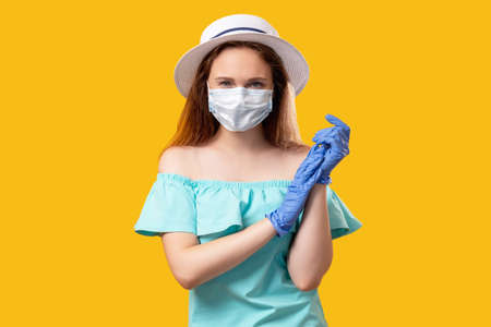 Quarantine fashion. Pandemic hygiene. Confident woman posing in protective face mask gloves summer...