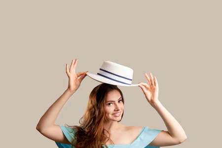 Summer outfit. Female elegance. Beautiful happy woman in off-the-shoulder blue dress holding white...