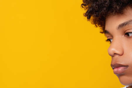 Black teenager portrait. Ethnic tolerance. Sad young african male isolated on orange copy space closeup. Melancholic emotion. No racism. Advertising backgroundの写真素材