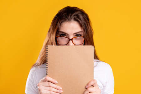 Teacher portrait. Business coaching. Confident smart woman in glasses hiding behind beige blank...