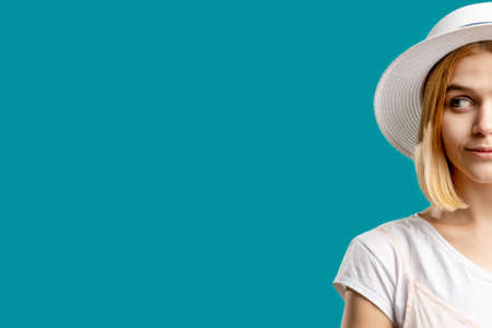 Holiday vacation. Sun protection. Smiling woman in white isolated on blue half face copy space. Skincare products. Travel journey. Aesthetic cosmetology. Advertising backgroundの写真素材