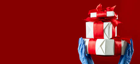 Christmas gifts. Covid-19 protection. Greeting boxes. Safety delivery. Holidays 2021. Hands in...