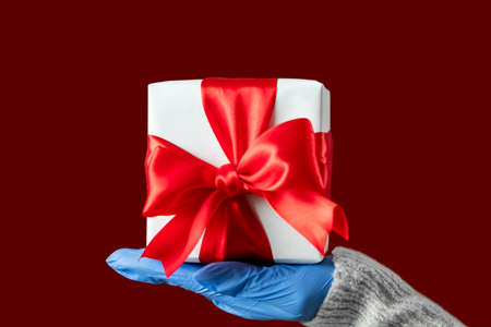 Christmas pandemic. Gift delivery. New Year 2021. Stay safe. Female hands in protective gloves...