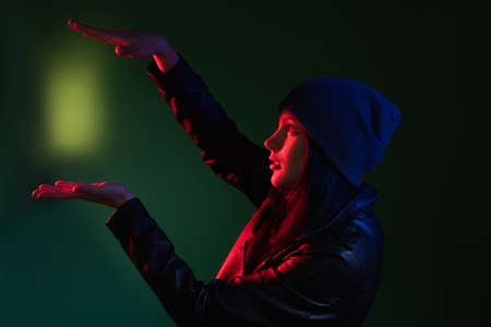 Night portrait. Female energy. Magic trick. Profile portrait of enthusiastic street style woman in...