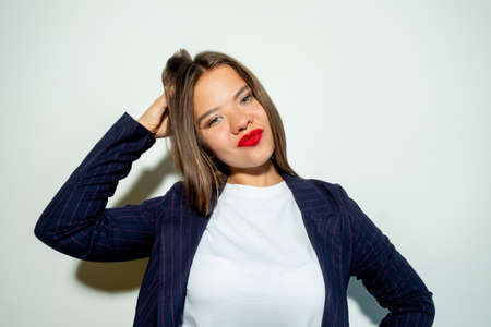 Doubtful business woman. Hard choice. Problem solution. Tough decision. Portrait of confused lady touching head looking at camera isolated on light neutral copy space background.の写真素材