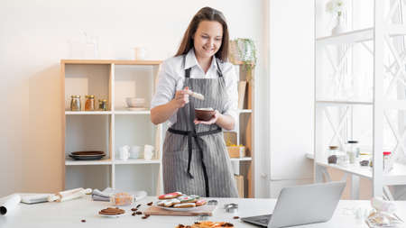 Bakery online school. Virtual masterclass. Festive homemade cookies. Happy woman looking laptop...