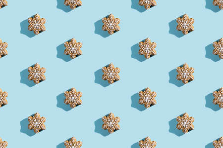 Christmas star pattern. Festive decorated cookies. Traditional bakery. New Year holiday. Sweet white icing figure biscuits isolated on blue pastel.の写真素材