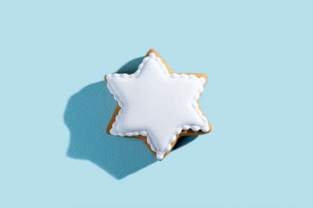 Christmas festive bakery. Traditional cookies. New year pastry. Homemade culinary. Gingerbread decorated white icing star isolated on blue pastel background.の写真素材