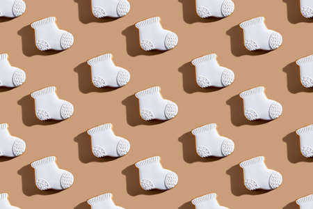 Bakery stocking pattern. Christmas pastry food. Festive winter decor. Cookies art. Gingerbread biscuits socks white icing isolated on beige background.の写真素材