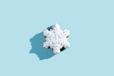Christmas star cookies. Festive food illustration. Traditional pastry. Gingerbread biscuit with white icing winter ornament isolated on blue pastel background.の写真素材