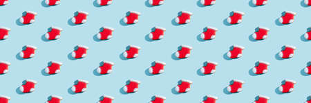 Christmas stocking cookies. Festive bakery pattern. New Year decor. Traditional winter sweets. Gingerbread biscuit figures boot red white icing isolated on blue pastel landing wide.の写真素材