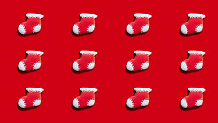 Christmas stocking pattern. Red seamless background. Winter holidays decoration. Santa sock design cookie minimalist symmetrical festive arrangement isolated on bright.の写真素材