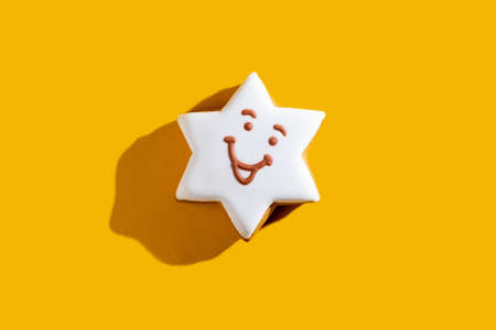 Fun sweet decor. Cute star. Bakery food art. White smiley figure biscuit. Positive emotion sticker for kids. Modern ornament isolated on bright orange copy space background.の写真素材