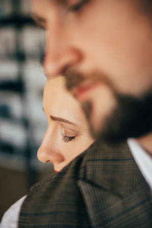 Harmony couple. Romantic love. Trustful relationship. Relaxed woman tenderly leaning hugging beloved man defocused closing eyes blur background.の写真素材