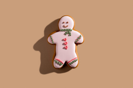 Pretty festive bakery. Valentines day pastry gift. Lovely cookies. Homemade colorful icing smiling gingerbread man isolated on beige pastel.の写真素材
