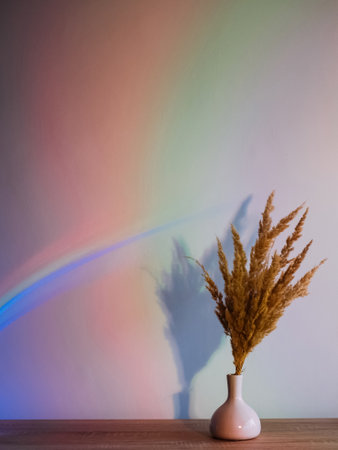 Neon light background. Plant decor. Night inspiration. Dry straw composition in vase on blur iridescent color gradient rainbow illuminated copy space wallpaper.の写真素材