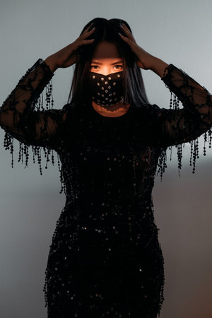 Pandemic fashion. Female beauty power. New normal lifestyle. Asian woman in black paillette dress...